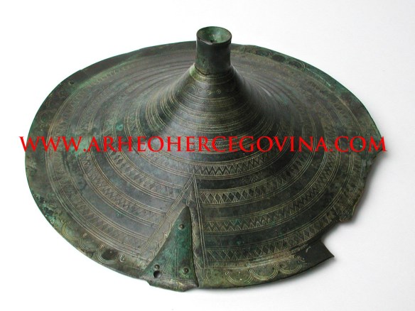 Brončani tutul iz ostave u Krehinu Gracu, ukrašen geometrijskim motivima. Smještaj Arheološka zbirka Franjevačkog muzej Humac kod Ljubuškog.